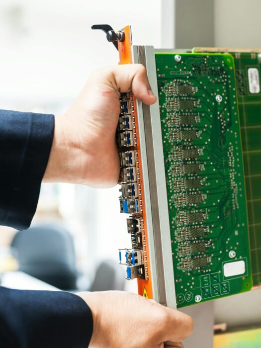 An IT technician removing a motherboard from a computer rack.