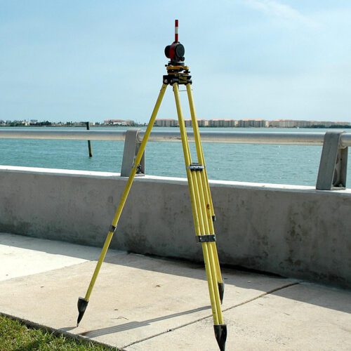 Surveying equipment on tripod overlooking water