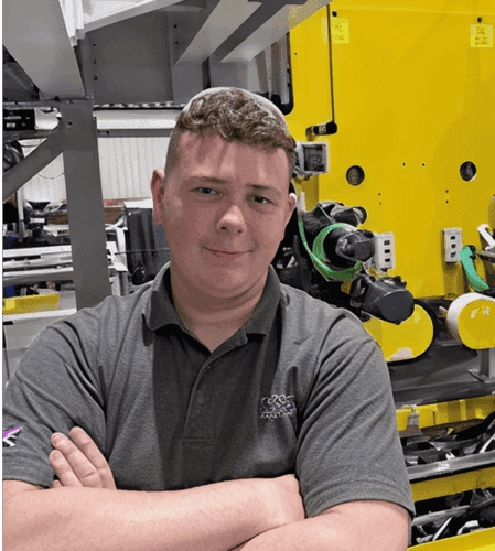 A picture of Ben stood in an factory.