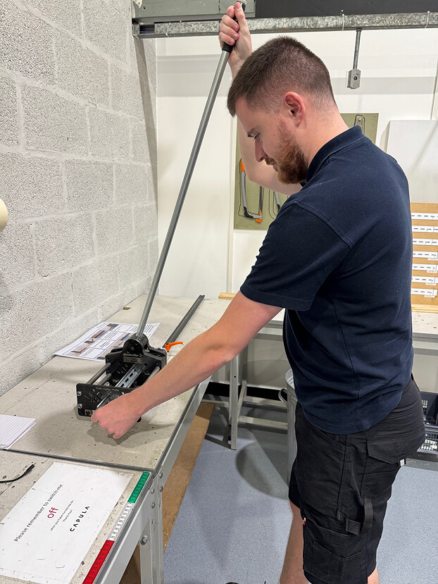 Daniel in the workshop, using a tabletop piece of equipment.
