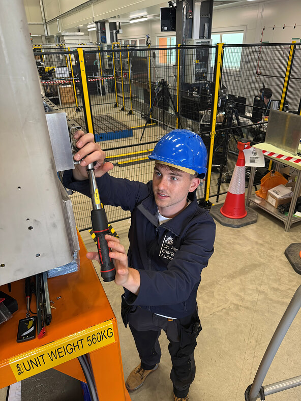Sam in a workshop using a torque wrench