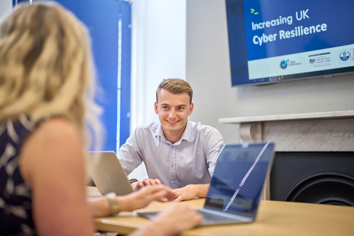 A cyber technician speaking with a client over a laptop