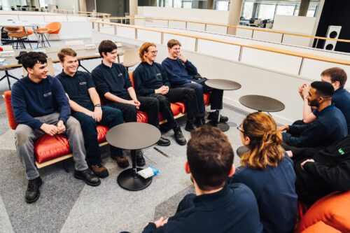Nine apprentices sitting on sofas socialising